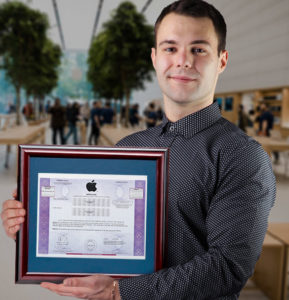 Николай Полетаев держит в руках сертификат Apple